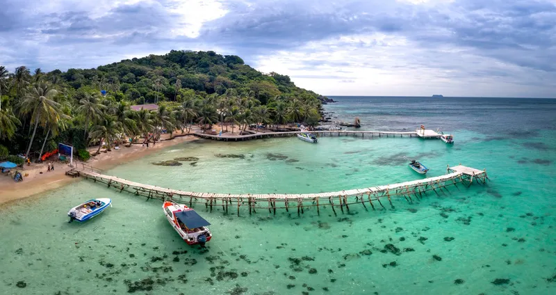 Beach with a wooden jetty and clear turquoise water