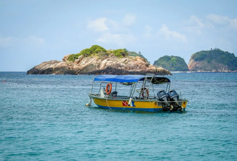 A motorboat on calm sea with islands behind
