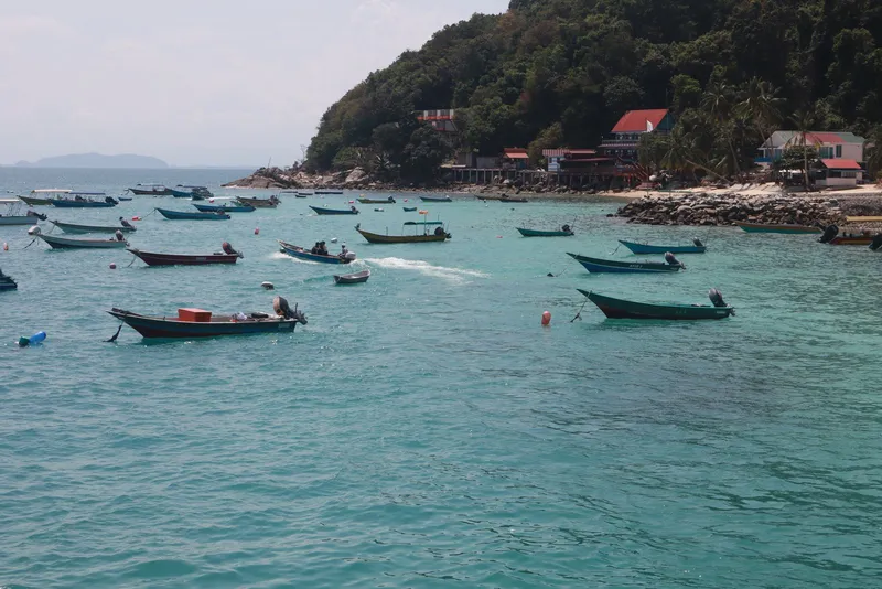 Small fishing boats on turquoise water under a sunny sky