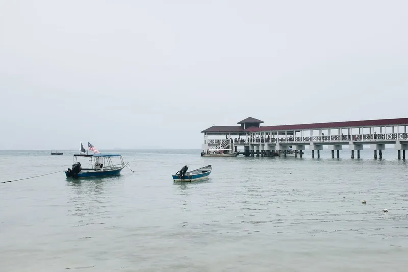 Seashore with boats and a pier
